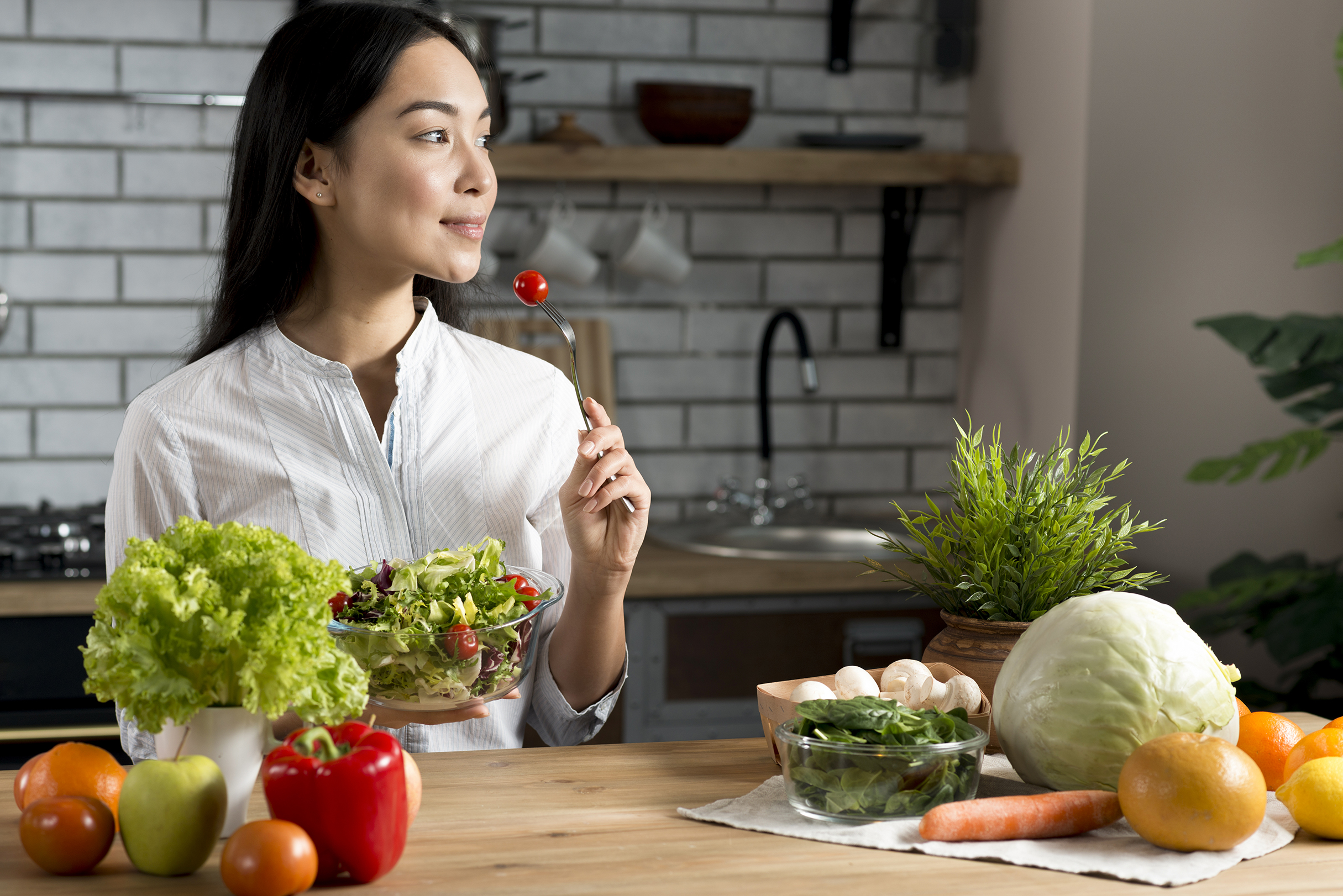 pretty-young-woman-eating-red-cherry-tomato-holding-bowl-mixed-salad